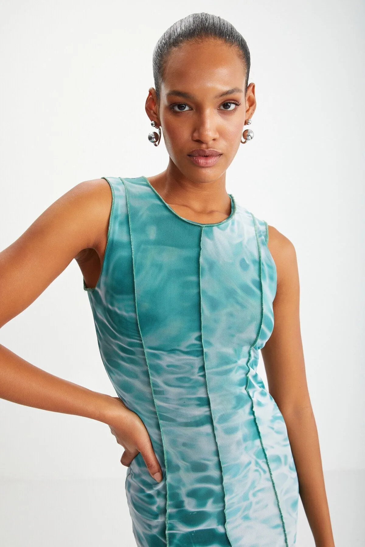 Bodycon green water patterned dress sitting on the islands with female tulle mesh fabric lining